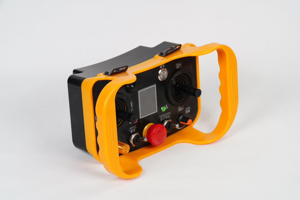 Wireless pendant remote controller for Shenghe AGV tractor — dual joysticks for forward/reverse and steering, emergency stop, status display. Operates both units of a tandem pair under sync mode.